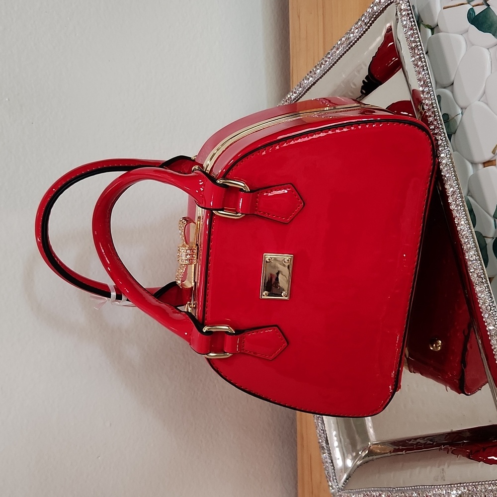 Adorable red patent purse with a pave rhinstone bow closure!